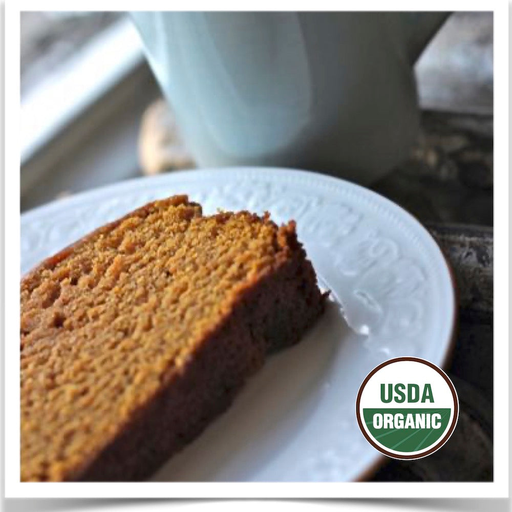 A slice of Prairie Road Organic Seed 's Uncle David's Dakota Dessert squash bread with coffee.